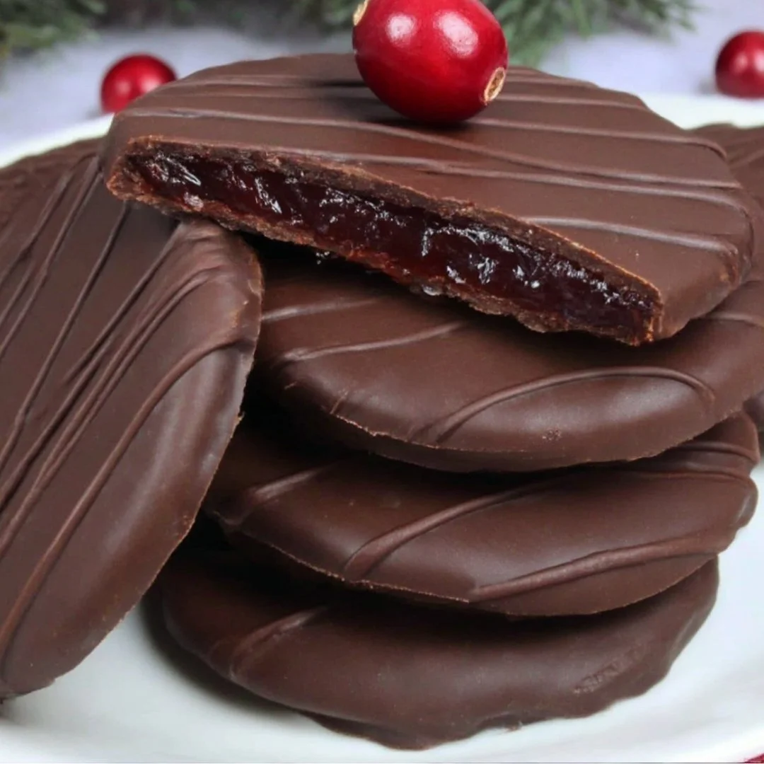 Dark chocolate covered cranberry sauce bites on a white plate